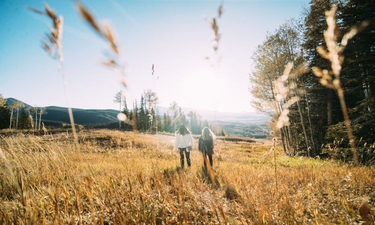Telluride Two women walking through a field.
